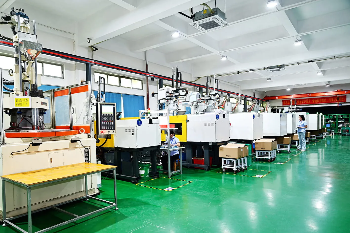 MOLDITQUICK injection molding hall β a row of presses with take-out robots running OEM production programs