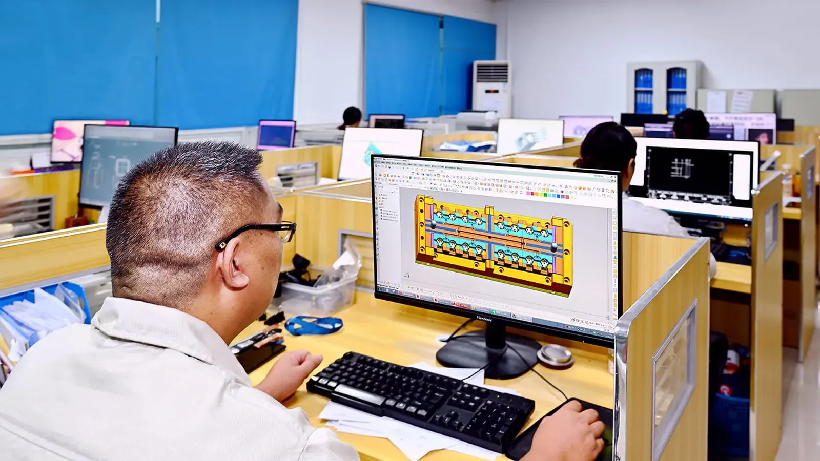 Engineer modeling a mold at a CAD workstation in the R&D department