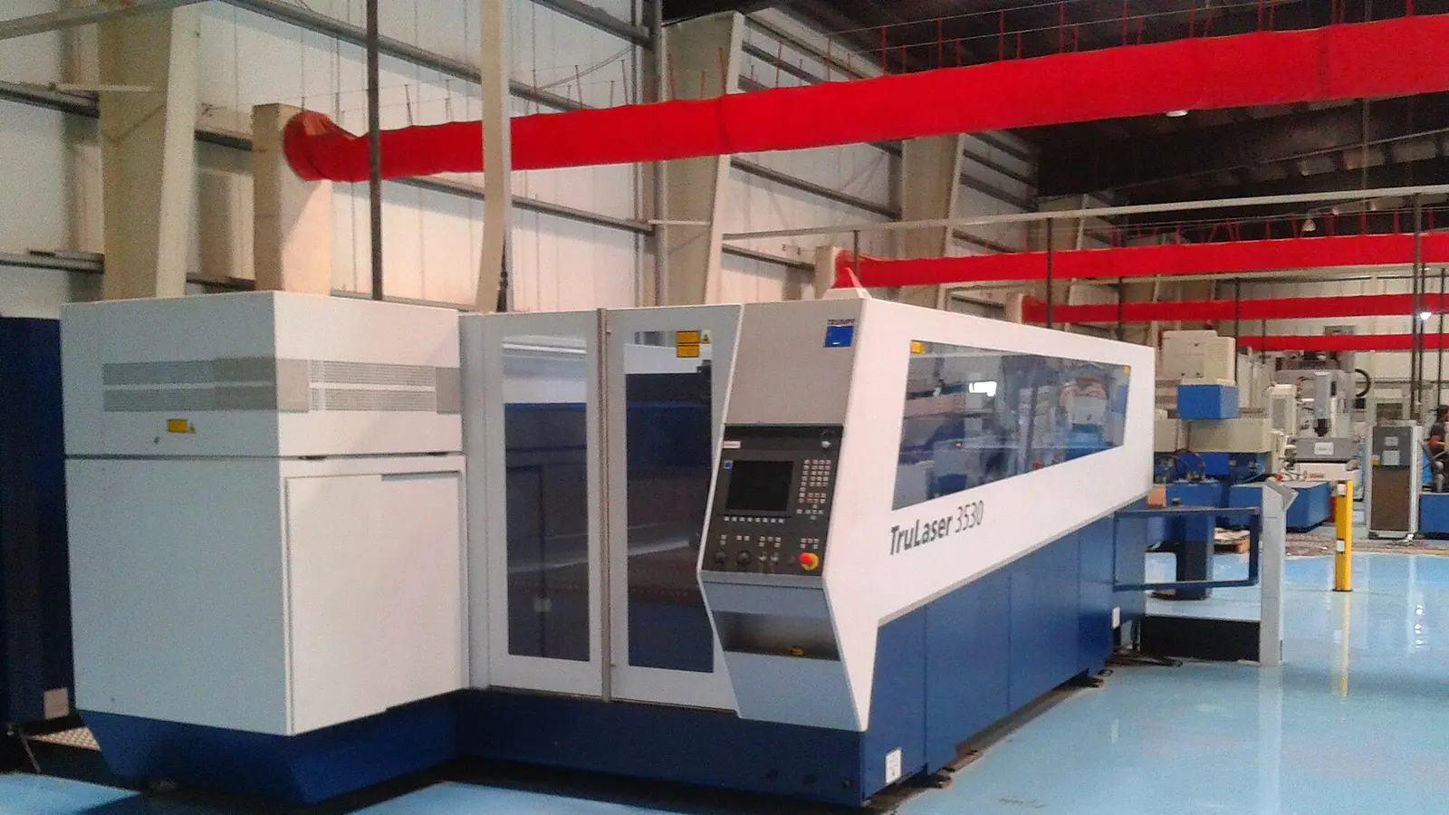 Enclosed fiber laser cutting machine on a blue epoxy floor